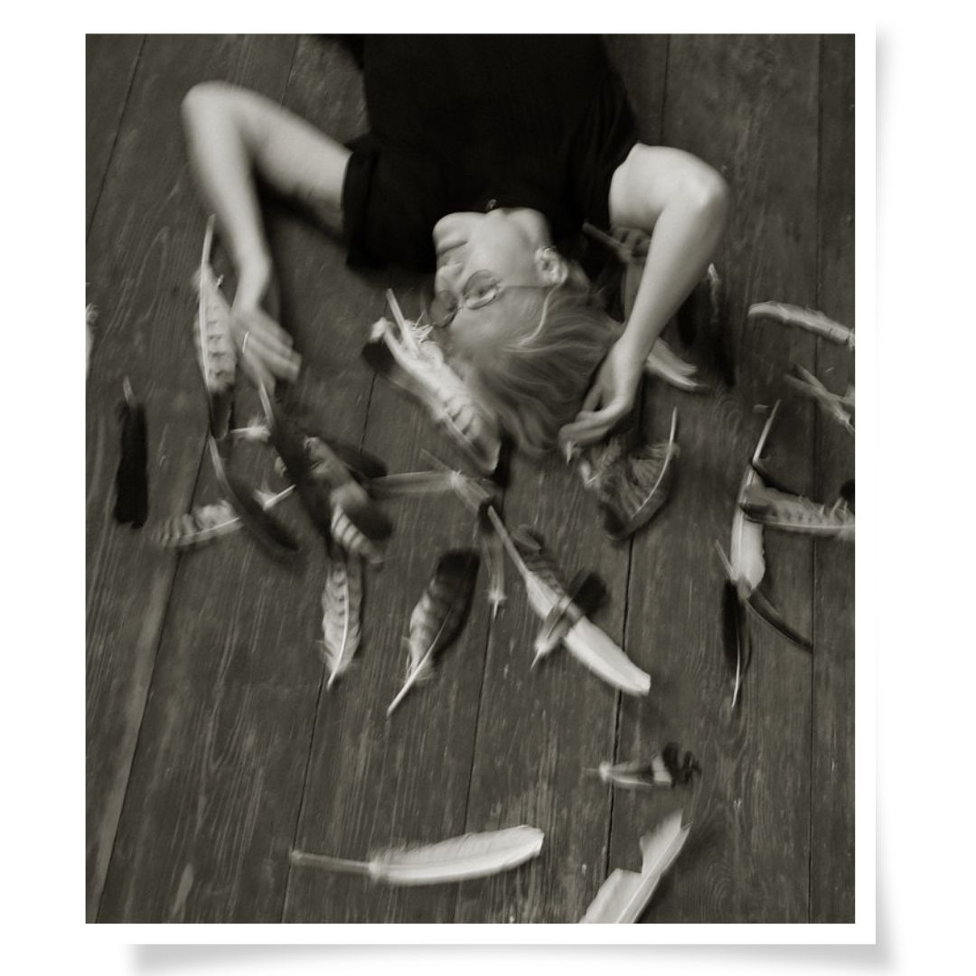 Experimentelles Portrait "Auszeit", Frau liegt zwischen Federn, poetische Fotografie Sachsen