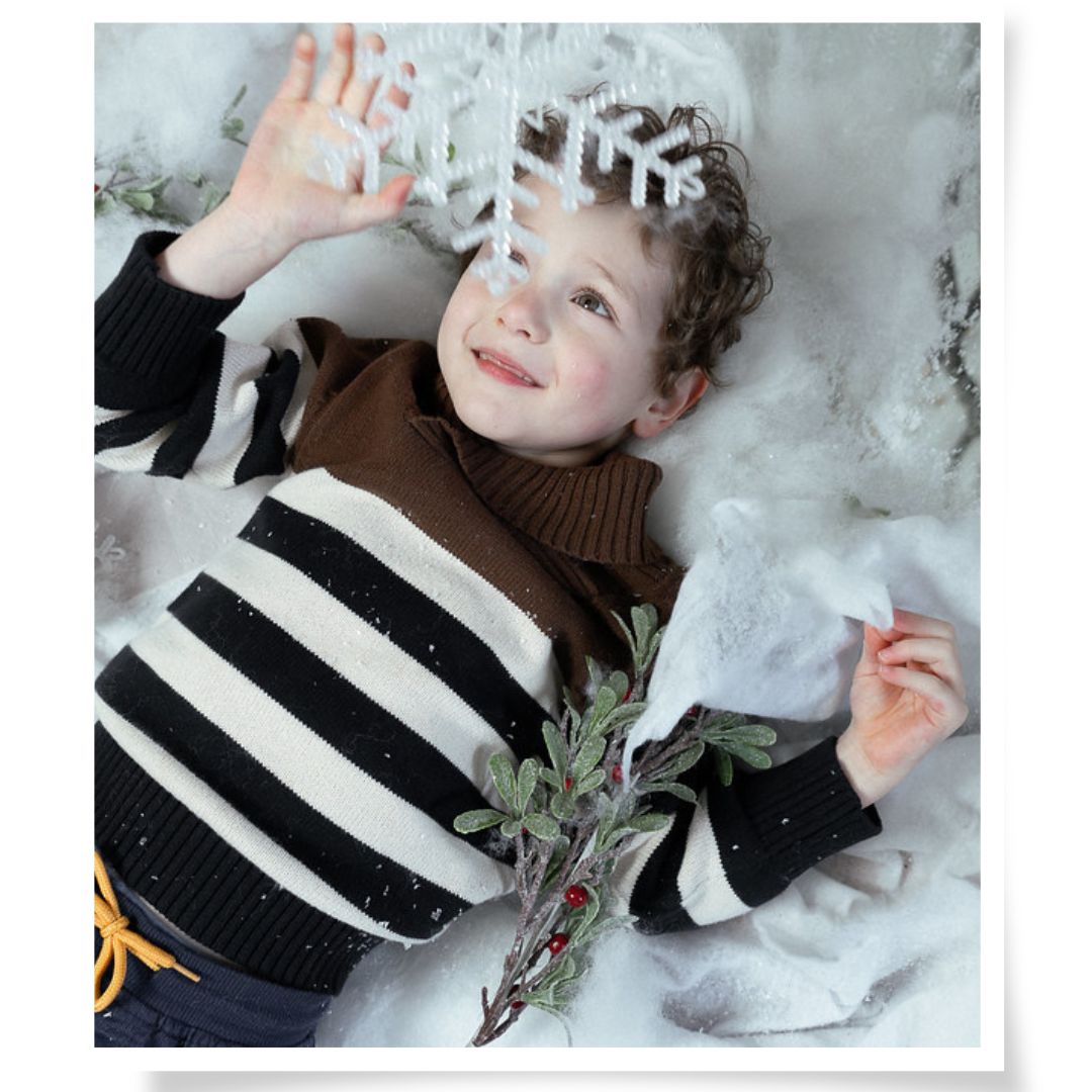 Winter-Familien-Shooting bei Chemnitz, Junge im Schnee mit Zweig, poetisches Kinderportrait