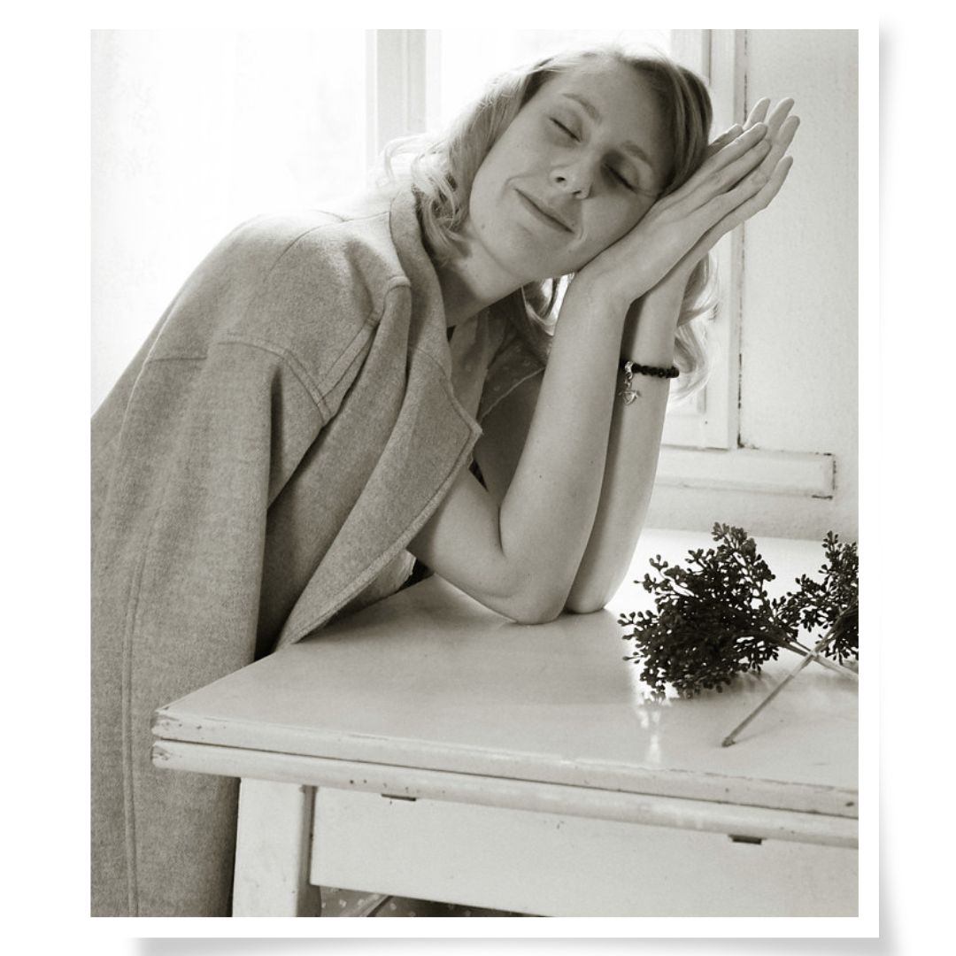 Babybauch-Portrait im Na.M.photo-Atelier, Frau am Tisch mit Blumen, ruhige, poetische Stimmung